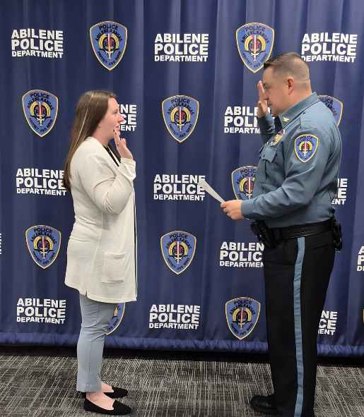 Officer administering oath to new Abilene Police Department employee.