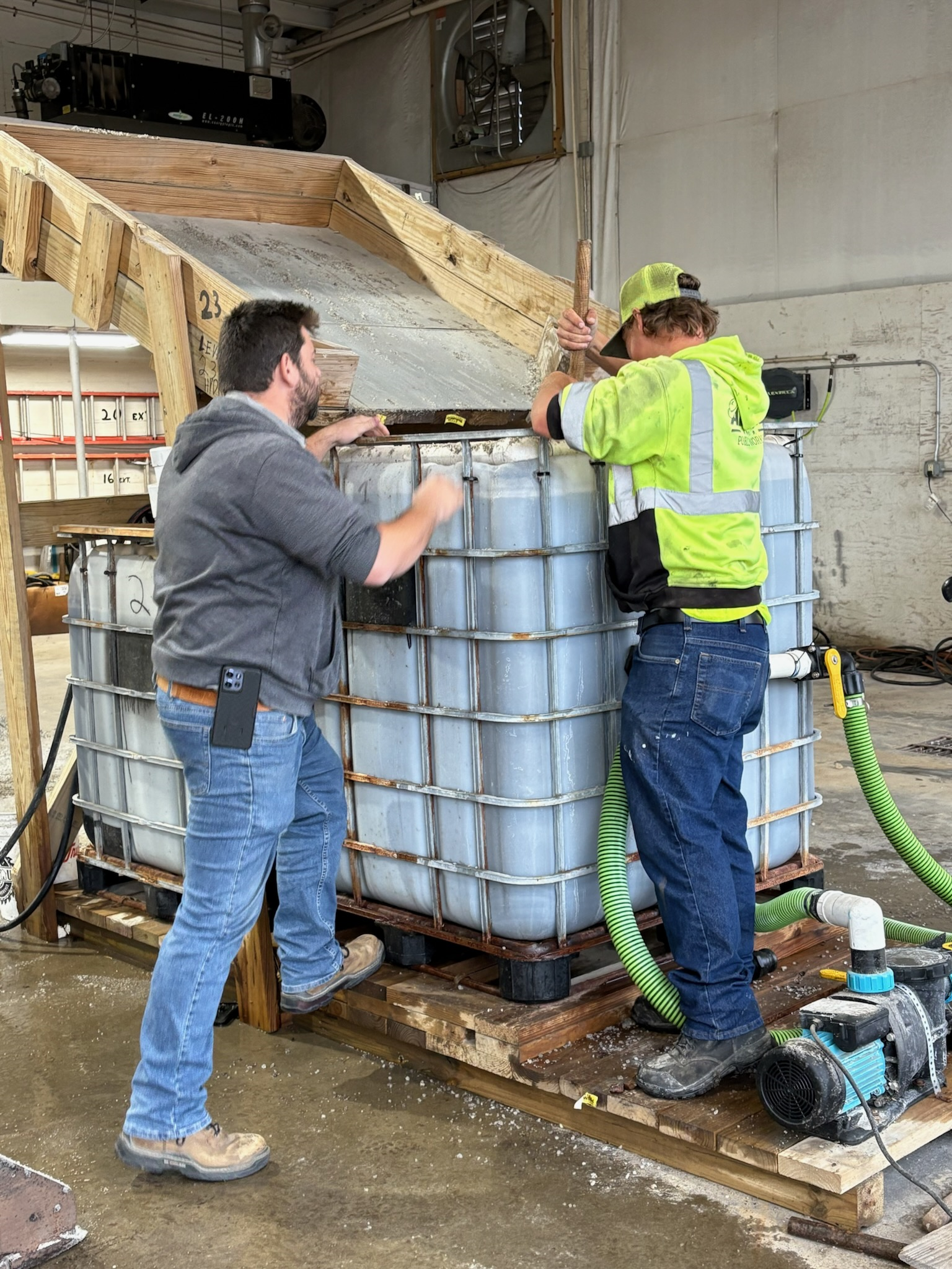 Public Works staff mixing material in a large brine tank during snow and ice training.